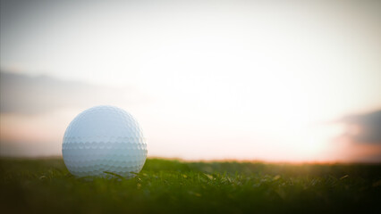 Golf ball resting on grass at sunset on golf course