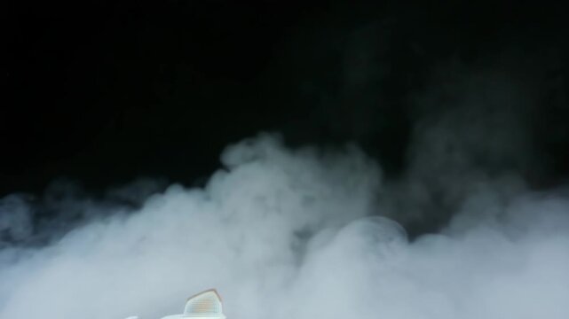 Endless loop of dense spooky fog rolling slowly across a dark background, cinematic horror atmosphere, soft ghostly light, seamless animation.