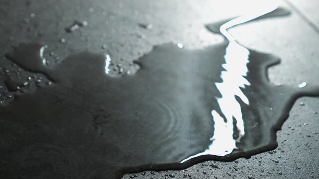 Running water pouring onto the floor.
Leaking water on the floor.
Lots of spilled water on the floor and splashes from drops falling into a puddle