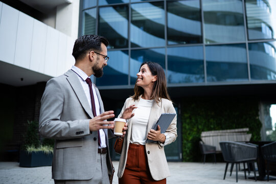 Businesspeople talking and walking outside office building - Powered by Adobe