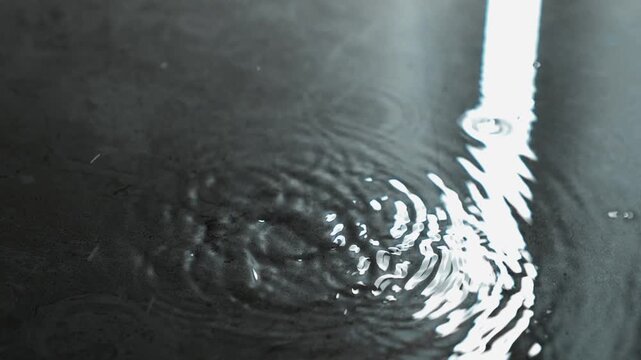 a stream of water pours from the ceiling onto the floor during a flood.
A puddle of water on the floor into which drops of water fall from above.
A large puddle on a ceramic floor in a house