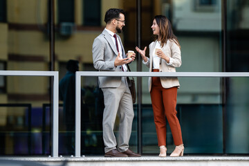 Business colleagues enjoying coffee break and conversation outdoors