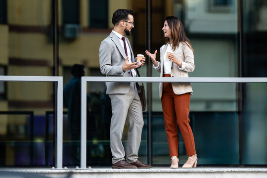 Business colleagues enjoying coffee break and conversation outdoors - Powered by Adobe