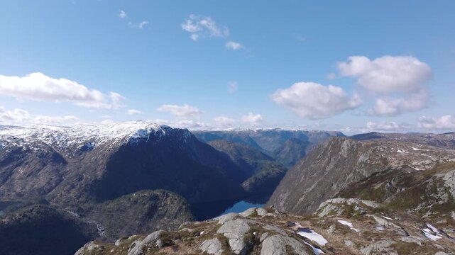 Cinematic aerial footage gliding over Matrefjellene mountains, capturing rugged peaks, snow, and springtime alpine beauty