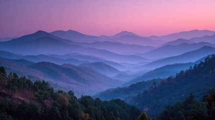 Fototapeta premium Panoramic view of layered mountains at sunset, exhibiting a gradient of purple and blue hues