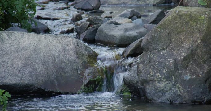 shot of water on a small rocky stream brook at new quay beach