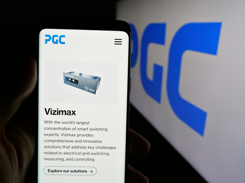 Stuttgart, Germany - 08-22-2025: Person holding cellphone with webpage of US company Power Grid Components Inc. (PGC) on screen in front of logo. Focus on center of phone display.