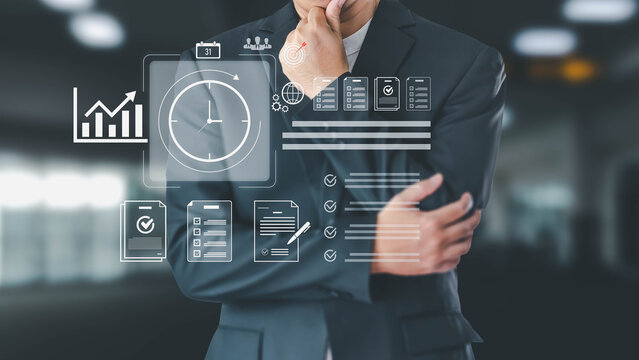 A businessman in a suit thoughtfully analyzes a futuristic digital interface showing time management, project goals, and performance charts. This illustrates modern business strategy and planning.