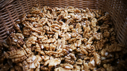 Close-up of many peeled walnuts in a large wicker basket