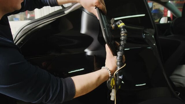 Specialist installs reflector board before dent removing. Technician works with tool to view surface and analyze condition of unevenness