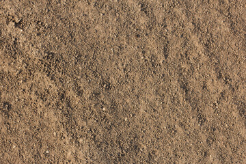 Natural dry soil surface with small stones and rough texture, detailed close-up background of earth ground 
