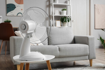 Electric fan on coffee table in living room at home