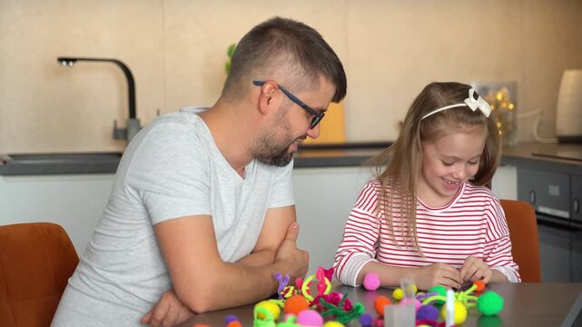 Happy family fun create diy from chenille wire. Father and little daughter make handmade craft. Leisure. Education