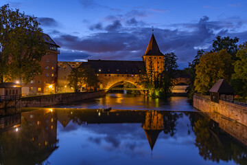 Schlayerturm Tower and Kettesteg bridge over Pegnitz River at blue hour,  Nuremberg, Germany