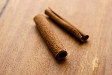Cinnamon sticks dried tree bark spice on rustic wooden table background.