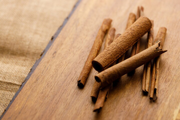 Cinnamon sticks dried tree bark spice on rustic wooden table background.