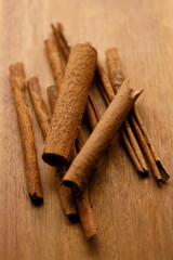 Cinnamon sticks dried tree bark spice on rustic wooden table background.