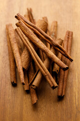 Cinnamon sticks dried tree bark spice on rustic wooden table background.