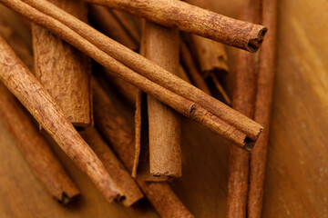 Cinnamon sticks dried tree bark spice on rustic wooden table background.