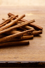 Cinnamon sticks dried tree bark spice on rustic wooden table background.
