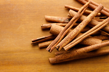 Cinnamon sticks dried tree bark spice on rustic wooden table background.
