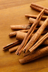 Cinnamon sticks dried tree bark spice on rustic wooden table background.