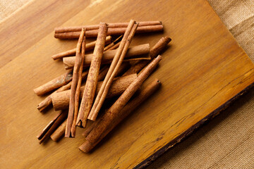 Cinnamon sticks dried tree bark spice on rustic wooden table background.