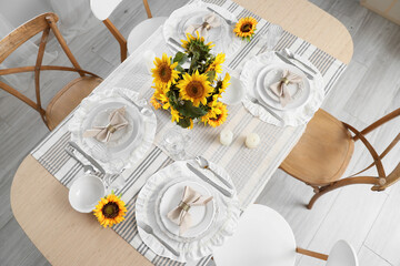 Elegant table serving with plates, folded napkins and beautiful sunflowers, top view