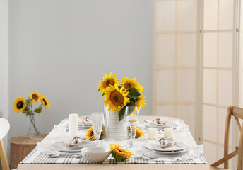Elegant table serving with plates, glasses and beautiful sunflowers