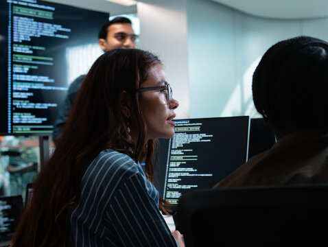 Group of A multicultural Software Developer working on laptop computer Writing Code on Desktop Computer in Co working Office Space. Professional Programmer Working on Coding Development Startup.