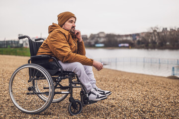 Portrait of paraplegic handicapped man in wheelchair. He is thoughtful and worried.