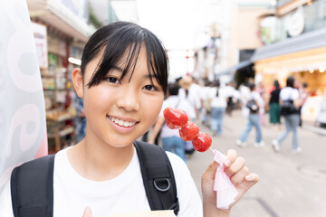 鎌倉観光をしながら食べ歩きをする10代の女性