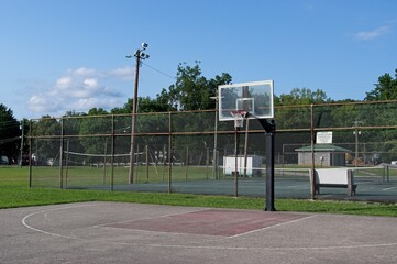 Basketball court in a municipal park with blue sky
