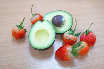 Fresh avocado and strawberries on the table.