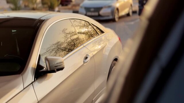 Cinematic 4K close-up of a sleek luxury car with golden-hour reflections on tinted windows. Perfect for auto ads, lifestyle visuals, travel, and transportation projects.