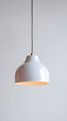 Fototapeta premium Modern white pendant lamp hanging against light wall. Clean, contemporary interior design perfect for lighting mockups or minimal aesthetics.