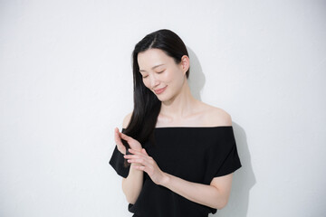 髪の毛の毛先のヘアケアをする女性　トリートメントや枝毛のイメージ © kapinon