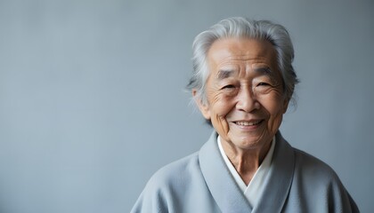 Elderly Woman Smiling in Traditional Attire with Soft Gray Background