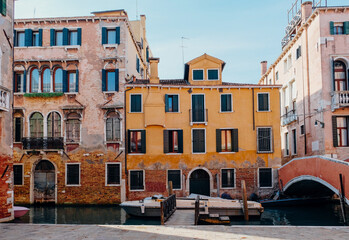 Typical Venetian view with water canal and colorful ancient buildings.