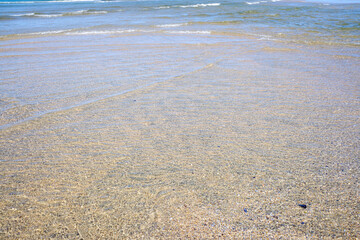 The Shoreline of a Beach with Clear Water and Sand. Concept A peaceful and serene coastal scene.