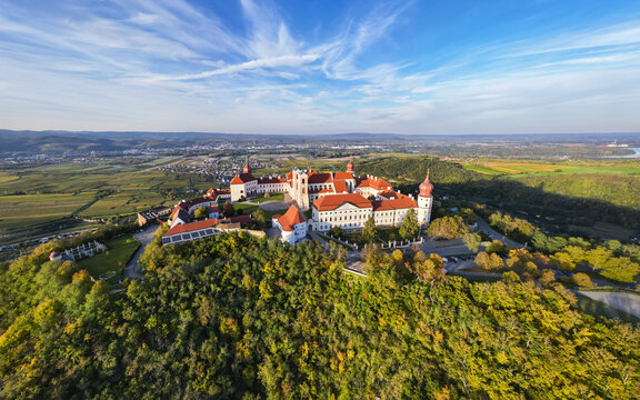 Aerial view of G&Atilde;&para;ttweig Abbey's striking red roofs and white walls atop a lush green hill against a bright blue sky, Furth bei G&Atilde;&para;ttweig, Nieder&Atilde;&para;sterreich, Austria.
