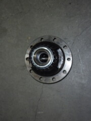 Top-down close-up view of a dirty, used metal automotive part, likely a wheel hub or differential...