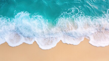 Fototapeta premium Aerial view of turquoise ocean waves breaking on a sandy beach.