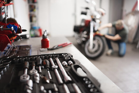 Man With Classic Motorcycle In Garage