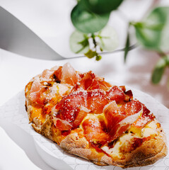 Delicious pizza topped with ham and cheese served at a restaurant during lunch