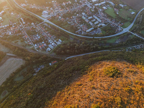 Aerial view of a winding road cuts through the landscape, revealing the vibrant hues of Ple&Aring;&iexcl;ivec's buildings amidst nature's embrace, Ple&Aring;&iexcl;ivec, Ko&Aring;&iexcl;ice Region, Slovakia.