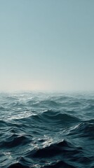 Calm ocean waves under a hazy sky