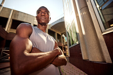 Confident athlete posing outdoors with urban architecture backdrop