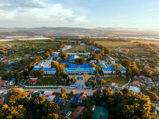 Aerial view of the Barotac Nuevo National Comprehensive High School, with its bright blue roofs contrasting against the surrounding greenery, Barotac Nuevo, Western Visayas, Philippines.