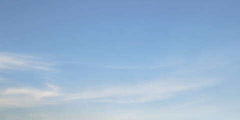 Clean soft pale blue sky with very faint almost imperceptible wisps cirrus clouds. Sky smooth gradient shifting from slightly lighter shade bottom pastel blue top. Peaceful and calm background